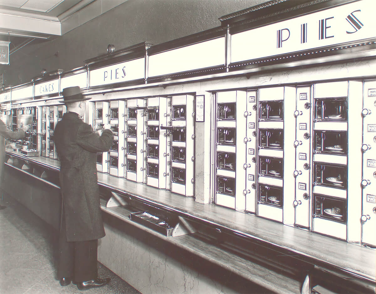 Man takes pie out of Automat, stone counters and walls below metal and glass display 1936 ©New York Public Library<p>© Berenice Abbott</p>