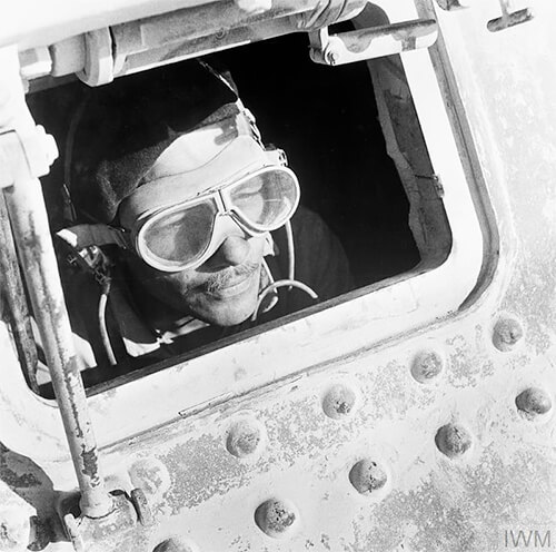 Cecil Beaton portrait of a British tank driver peering out of his Grant tank in North Africa, 1942. © IWM Non Commercial Licence<p>© Cecil Beaton</p>