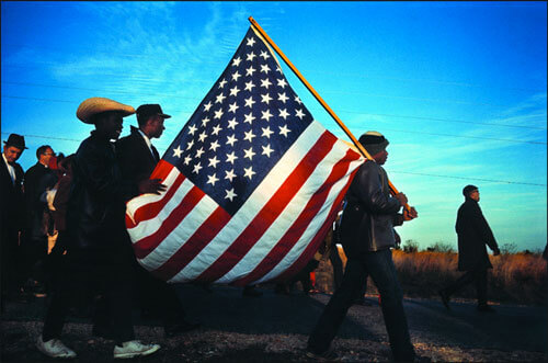 The Big Flag on the Hall Farm Road at the end of the 1st day of the Selma to Montgomery March, Alabama, 21 March 1965<p>© Dan Budnik</p>