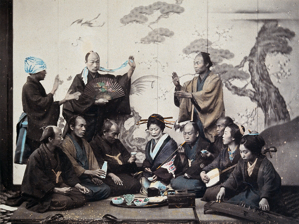 Japan: men and women in traditional dress sharing a meal and playing musical instruments, ca. 1868<p>© Felice Beato</p>