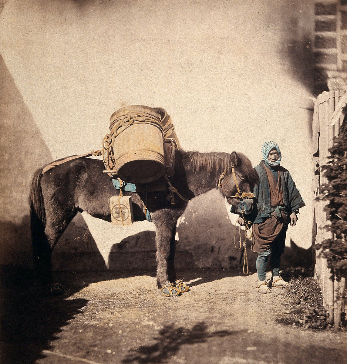 Takaido, Japan: a pack pony wearing straw shoes with its leader, ca. 1868<p>© Felice Beato</p>