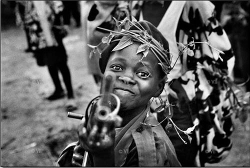 A child soldier with the Mayi-Mayi militia waits in Kanyabyonga as CNDP rebels advance. 2008<p>© Marcus Bleasdale</p>