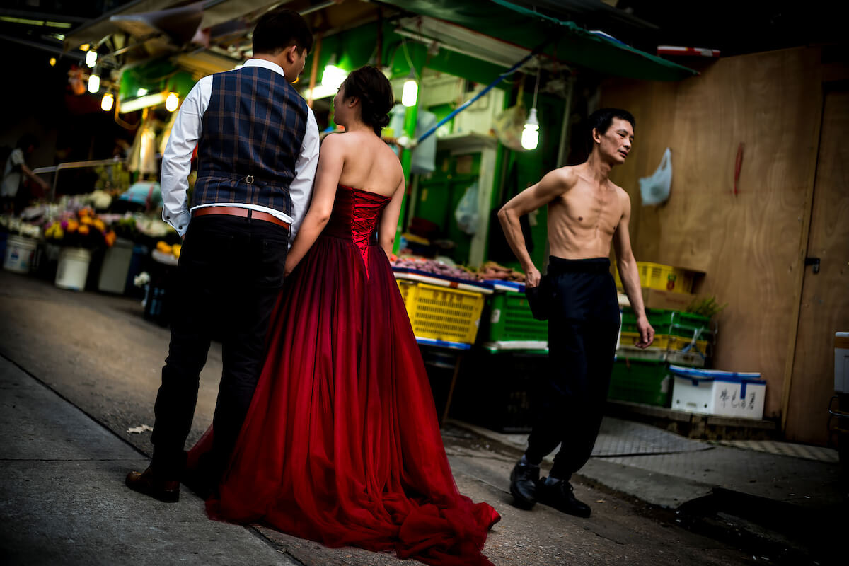 Hong Kong, China - Woman in a red velvet evening dress standing in a street with her boyfriend on May 01, 2018<p>Courtesy Redux Pictures / © Jean-Michel Clajot</p>