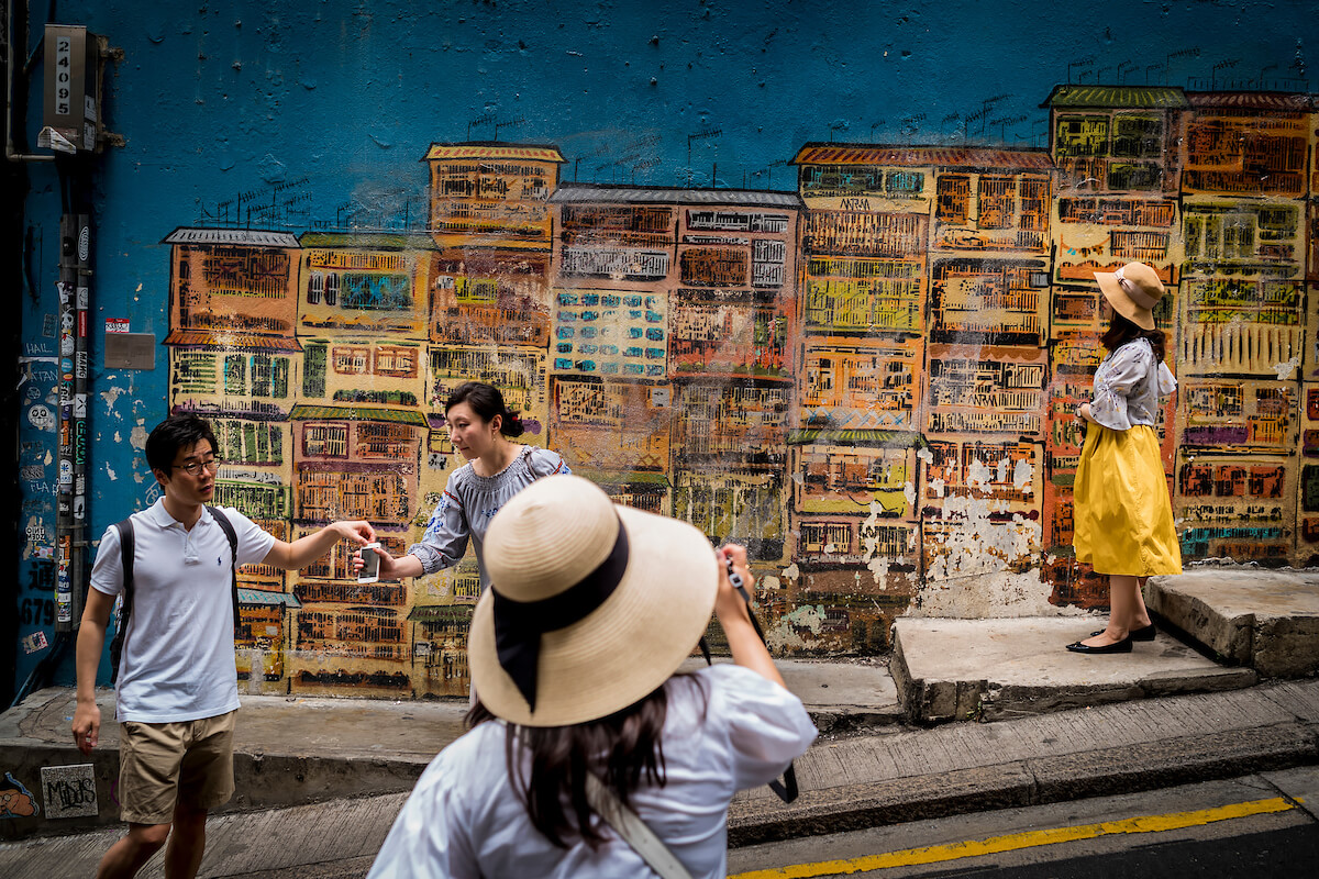 Tourists pose for photographs in front of street art along Graham Street in Hong Kong’s SoHo district on April 30, 2018<p>Courtesy Redux Pictures / © Jean-Michel Clajot</p>