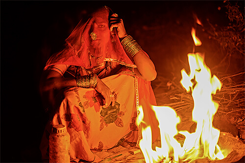 A Rajasthani girl sits by the campfire<p>© Robi Chakraborty</p>