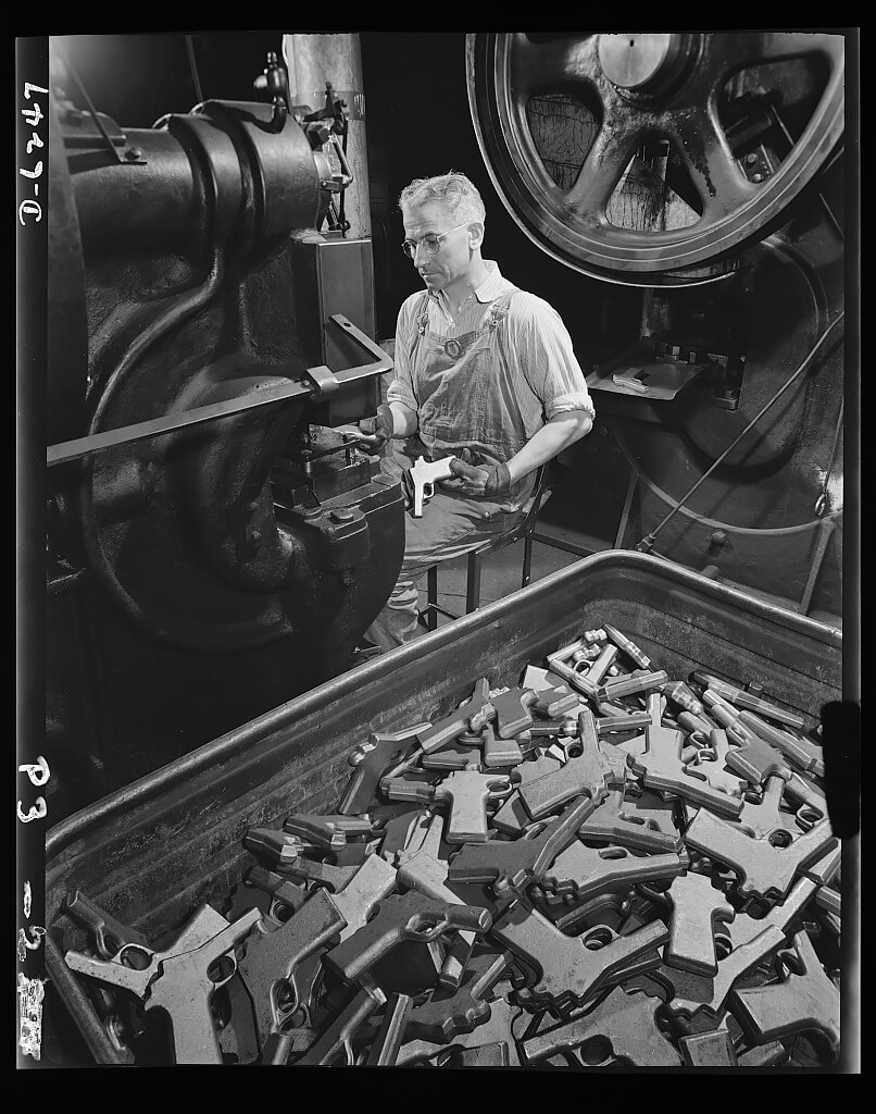 John Ignacek pierces trigger hole guards on .45-caliber automatic pistols in the plant of a large manufacturer of firearms. 1942<p>© Andreas Feininger</p>