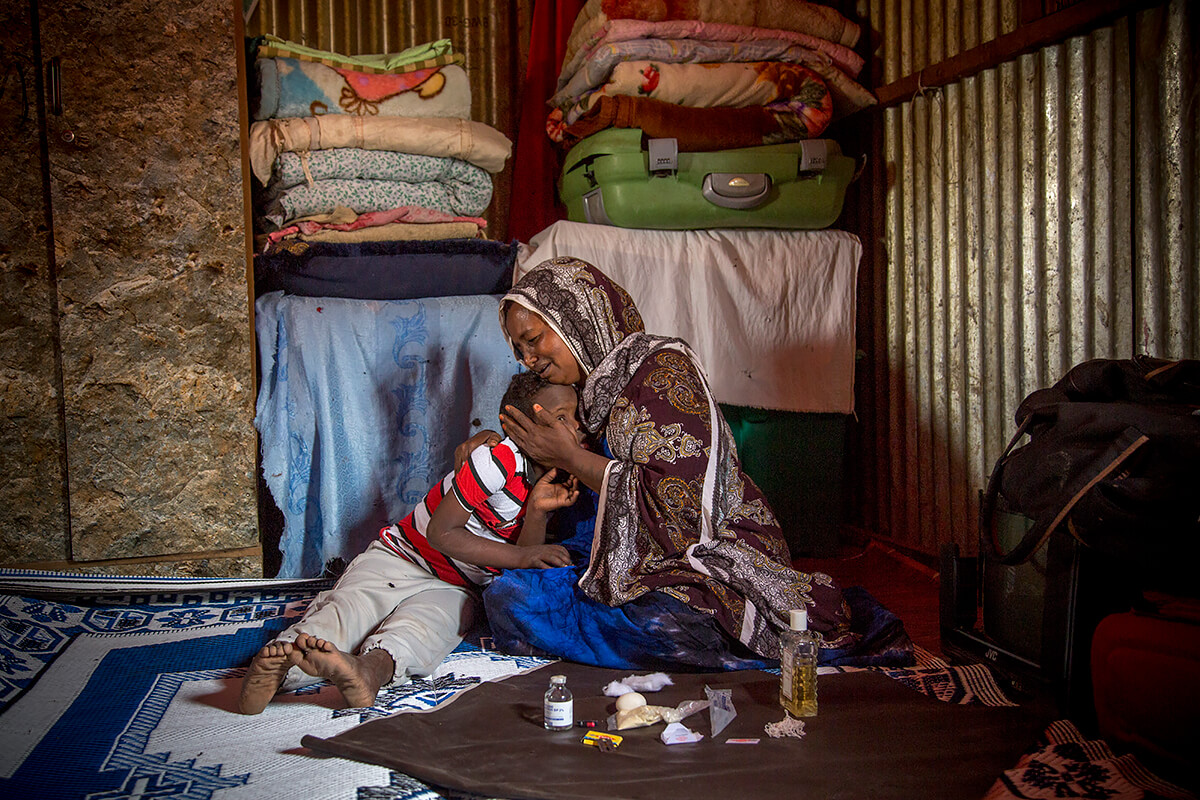Asha Ali Ibrahim, 41, Female Genital Mutilation practitioner with her 10 year old son who has Down’s Syndrome, Hargeisa in Somaliland, 2017<p>© Georgina Goodwin</p>