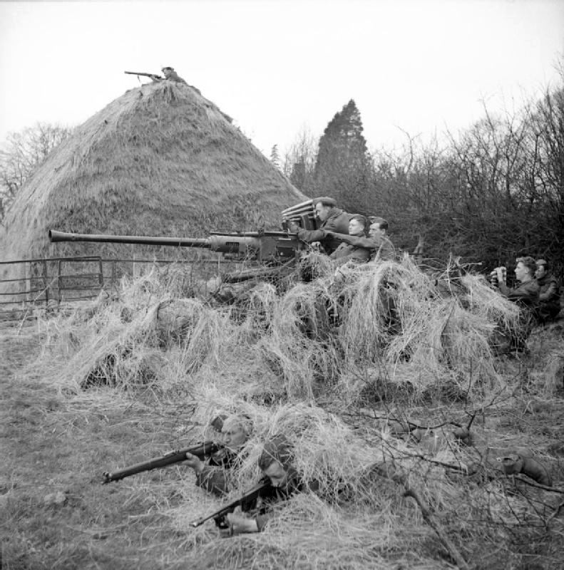 A Bofors 40mm anti-aircraft gun uses a hayrick for camouflage during Exercise ’Spartan’, 9 March 1943<p>© Bert Hardy</p>
