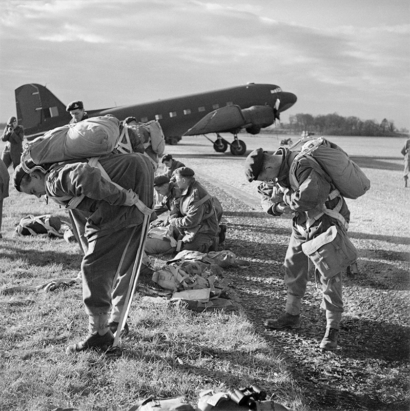 British paratroops fitting their parachute harnesses before entering a Dakota during a large-scale airborne forces exercise, 22 April 1944<p>© Bert Hardy</p>
