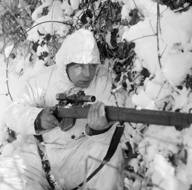 A 6th Airborne Division sniper on patrol in the Ardennes, wearing a snow camouflage suit, 14 January 1945<p>© Bert Hardy</p>