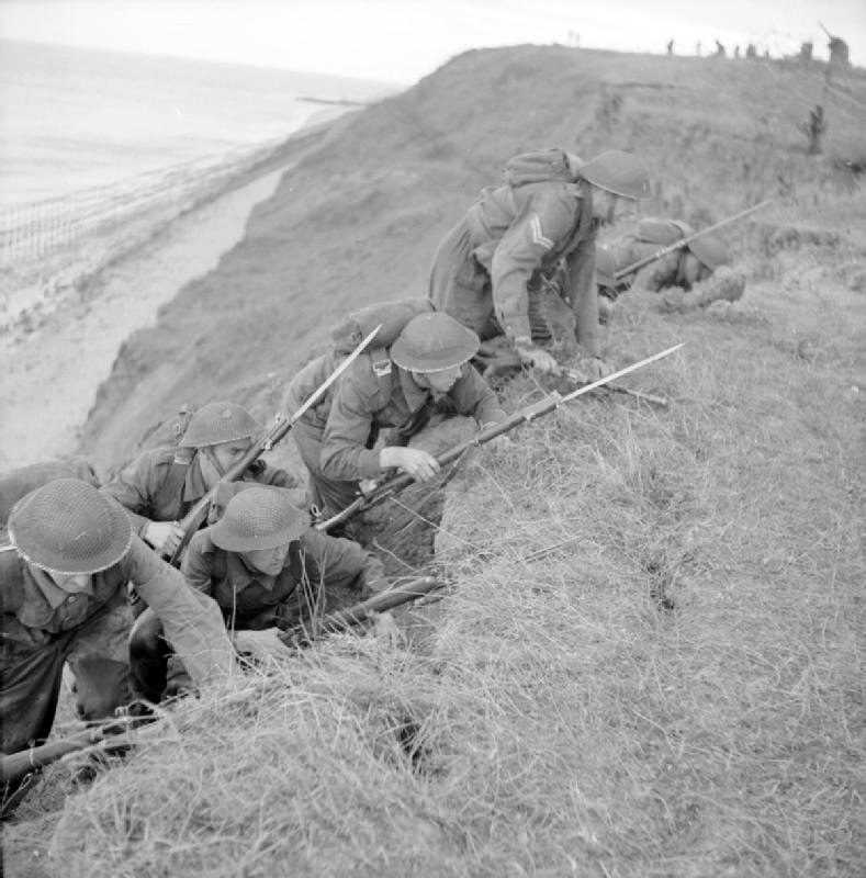 Infantry of 45th Division climb up cliffs at Frinton-on-Sea, Essex, 16 October 1942<p>© Bert Hardy</p>