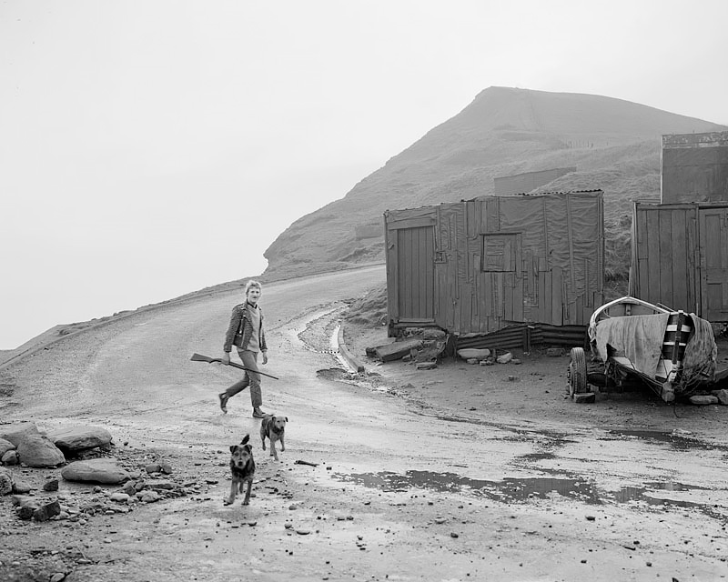 Leso with a gun and his dogs, Skinningrove 1984<p>© Chris Killip</p>