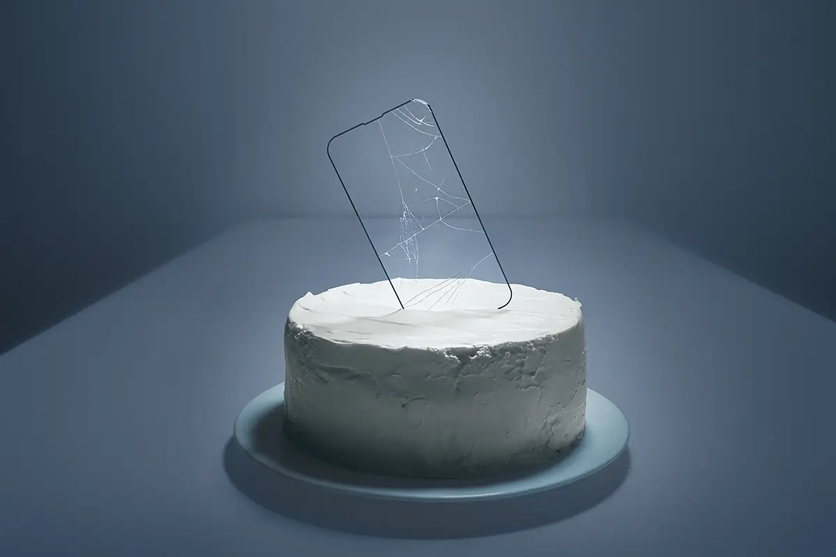 The Offering: A cracked screen protector is placed on a cake—a celebration interrupted<p>© Kantaya New</p>