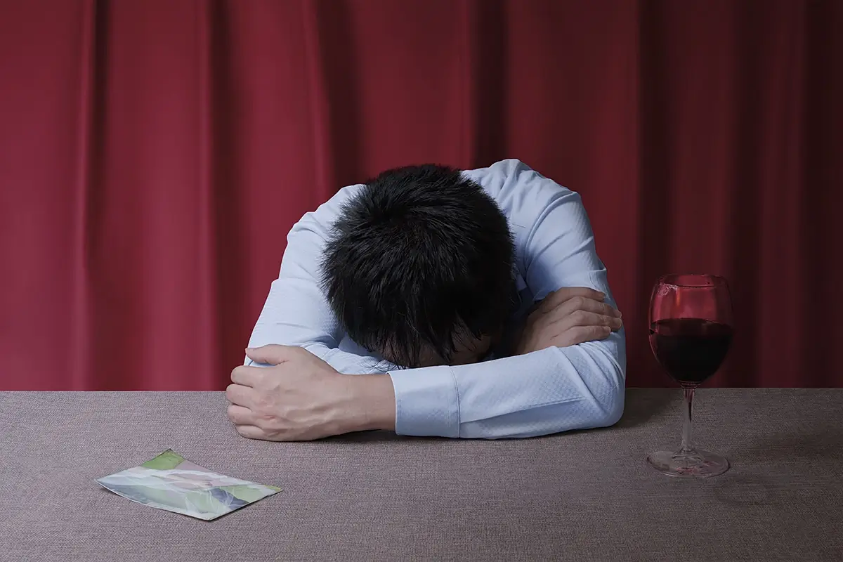 Apart: A desk. A half a glass of wine and a wedding photo remain.<p>© Kantaya New</p>