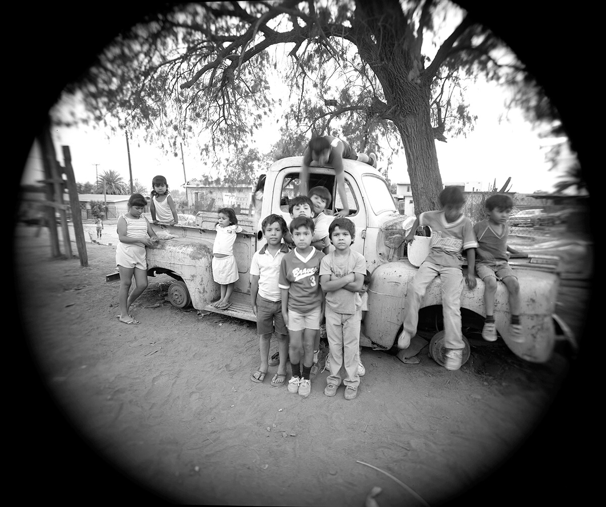 Boys pose by truck, others play<p>© Meg McKenzie Ryan</p>