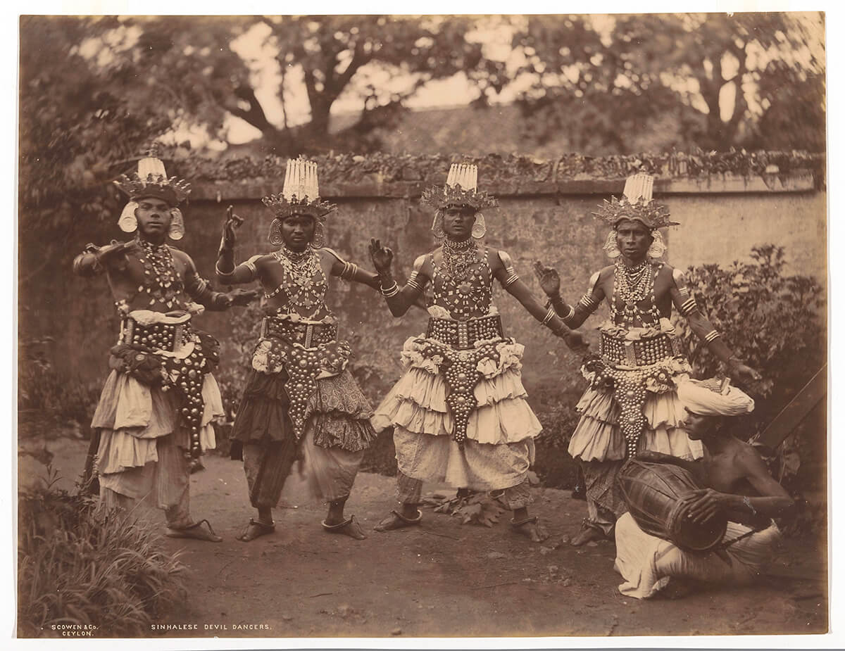 Four Sinhalese devil dancers in a ritual Sri Lankan dance, accompanied by a drummer, between 1870 and 1890<p>© Charles Scowen</p>