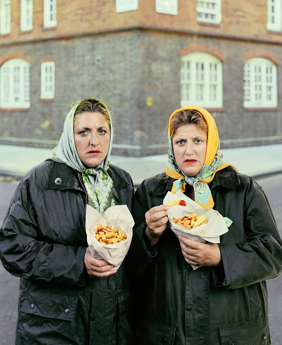 Sisters in scarfs eating pimlico chips<p>© David Stewart</p>