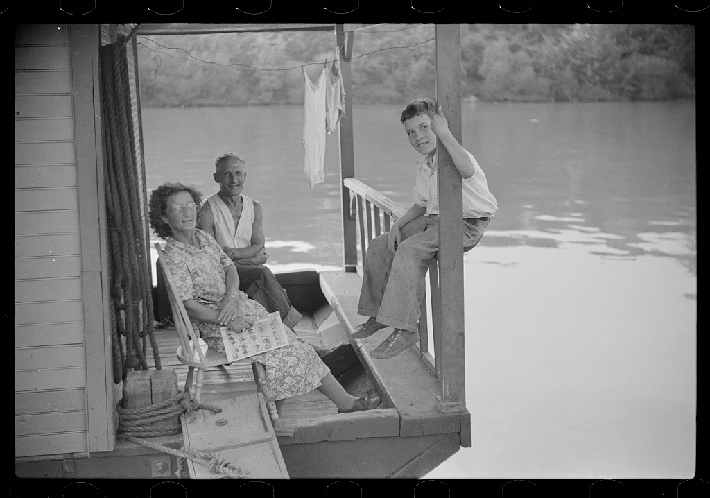 Family on front porch of houseboat on river in Charleston, West Virginia, 1938<p>© Marion Post Wolcott</p>
