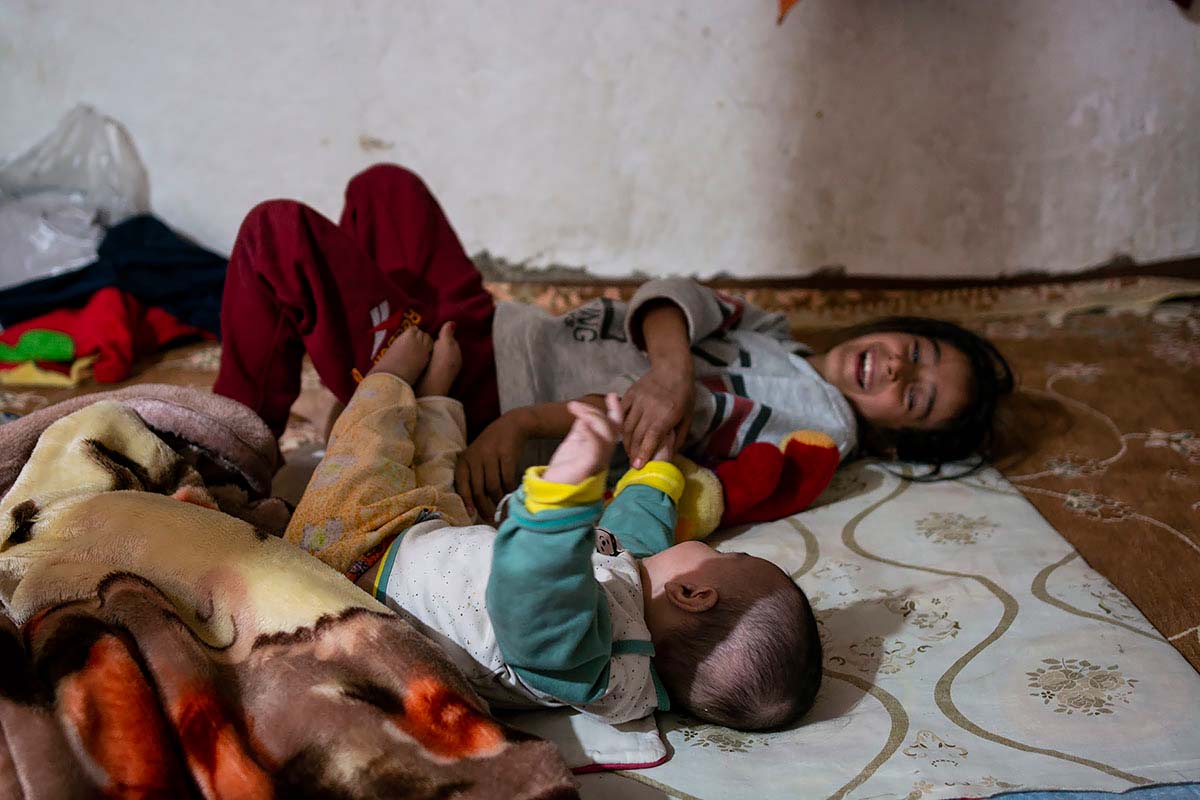 Mahsa is playing with Kasra. Mahsa feels responsible for her brother and helps her mother. Amir Ayyub, Fars Province, Iran, January 2021.<p>© Sajedeh Zarei</p>