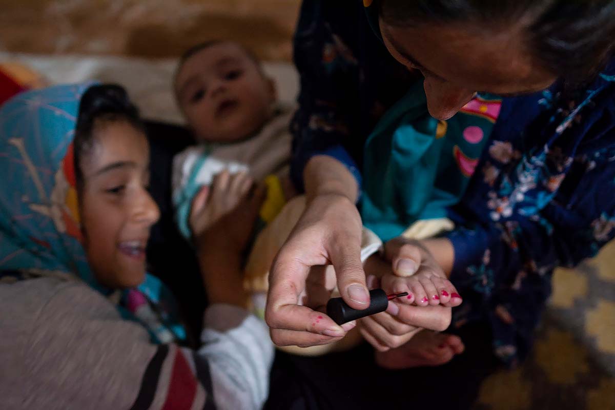 Asma is varnishing Kasra’s toenails. Amir Ayyub, Fars Province, Iran, January 2021.<p>© Sajedeh Zarei</p>