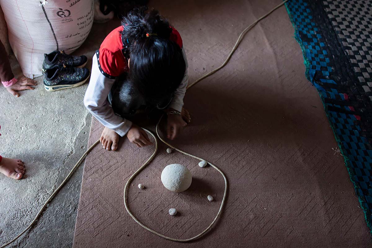 Mahsa uses stones to create a corona virus schematic. She surrounds it with a TV antenna to protect her pregnant mother. Amir Ayyub, Iran, May 2020.<p>© Sajedeh Zarei</p>