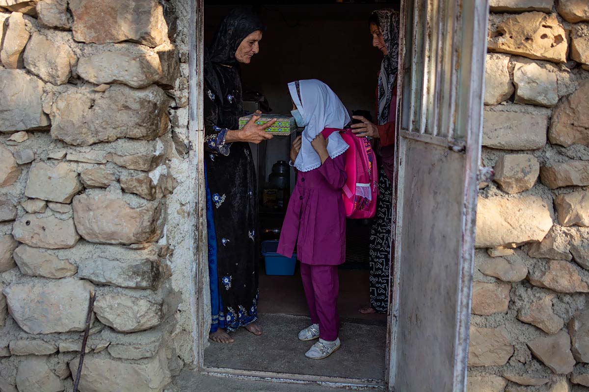 Today is the first day of Mahsa school. Her mother and grandmother pass her under the Quraan. Amir Ayyub, Iran, September 2020.<p>© Sajedeh Zarei</p>